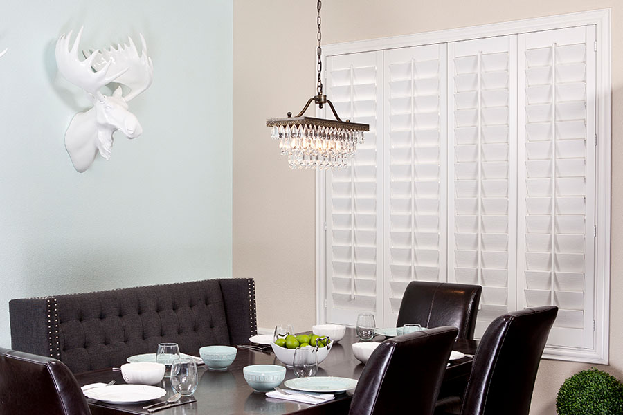 Closed white Polywood shutters on a dining room window