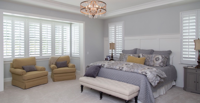 Indoor shutters offer subtle fashion. White shutters in Dallas bedroom.